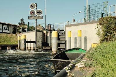 Buildings by river against clear sky
