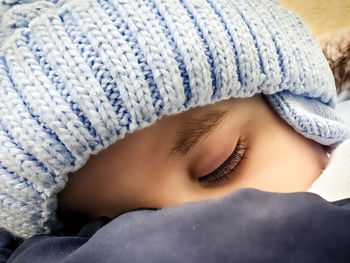 Close-up portrait of woman lying in snow