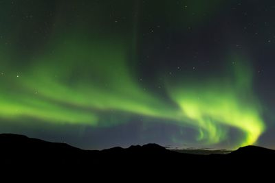 Low angle view of silhouette mountain against sky at night