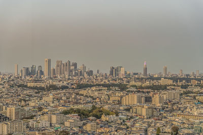 Aerial view of buildings in city against sky