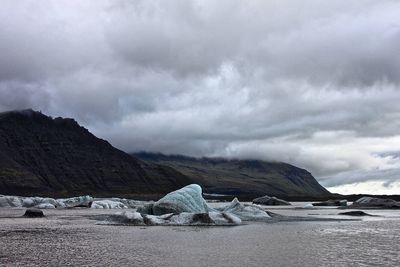 Scenic view of mountains against cloudy sky