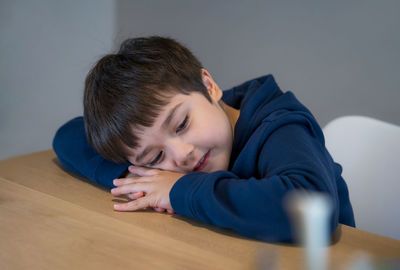 Portrait of boy lying on sofa at home