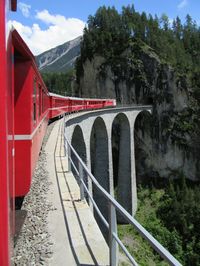 Train by railroad bridge against sky