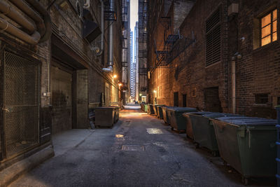 Illuminated street amidst buildings in city