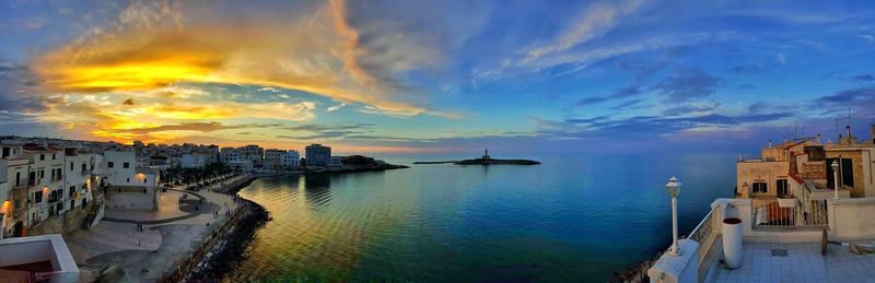 Buildings in city against cloudy sky