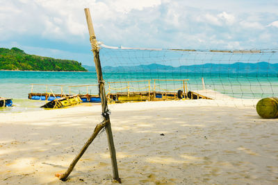 Fishing net on beach against sky