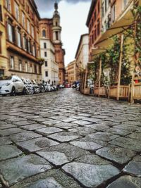 Close-up of cobblestone street against buildings in city