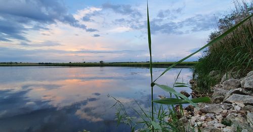 Scenic view of lake against sky at sunset