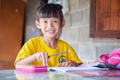 Portrait of smiling girl holding table