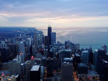 High angle view of buildings in city by chicago river against sky during sunset