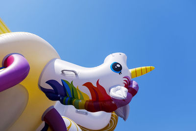 Low angle view of stuffed toy against clear blue sky