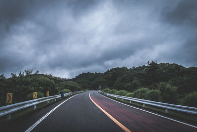 Empty road against cloudy sky
