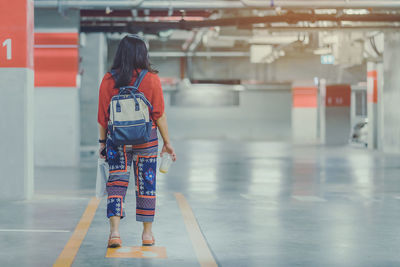 Rear view of woman walking in corridor of building