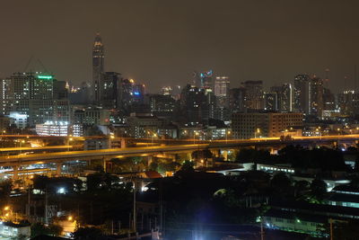 Illuminated buildings in city against sky at night