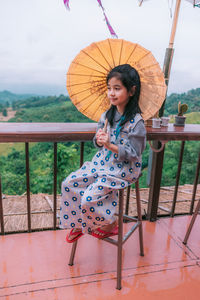 Full length of woman sitting on seat