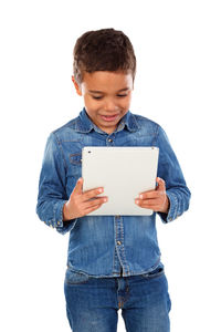 Boy holding smart phone while standing against white background