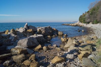 Rocks on beach against clear sky