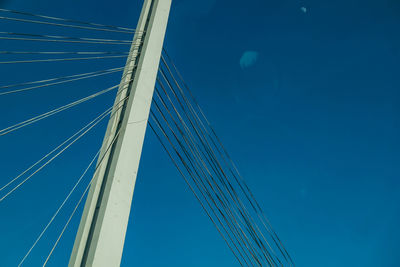 Low angle view of suspension bridge against sky