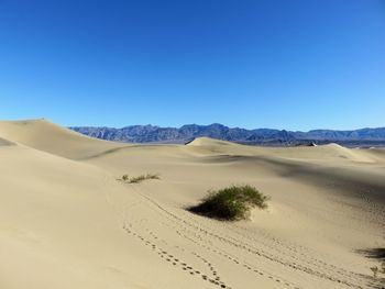 Scenic view of desert against clear blue sky