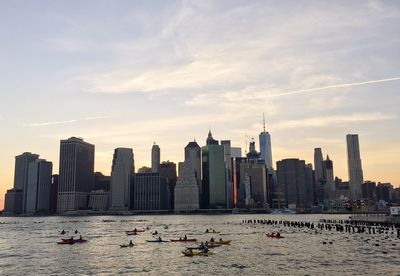 City at waterfront against cloudy sky