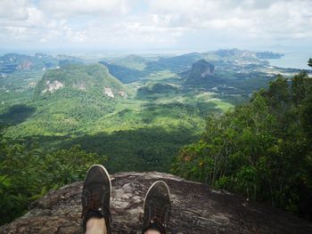 Low section of person on mountain against sky