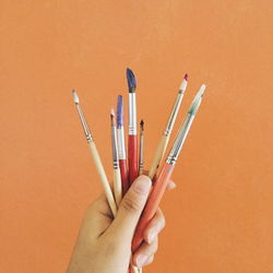 High angle view of human hand holding paintbrush