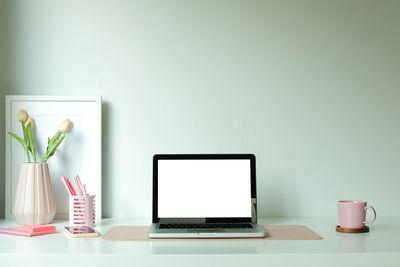 Low angle view of laptop on table against white background