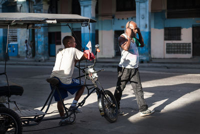 Man with bicycle on street in city