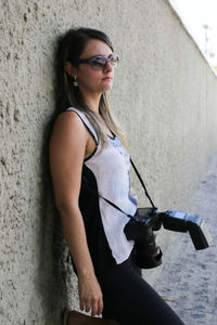 Side view of woman standing against wall