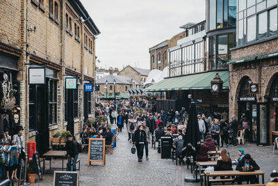 People walking on street amidst buildings in city