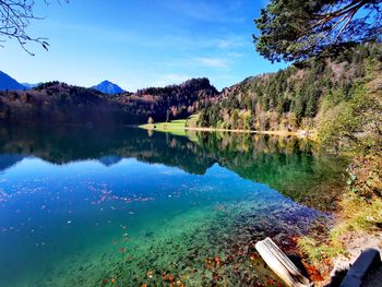 Scenic view of lake and mountains against blue sky