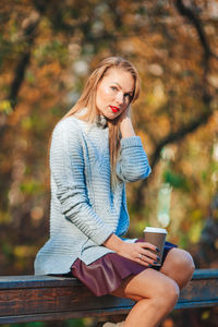 Young woman using mobile phone while sitting outdoors