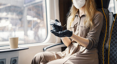 Young woman sitting on window sill