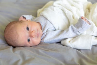 High angle view of cute baby lying on bed