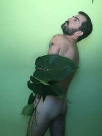 Portrait of young man standing against wall