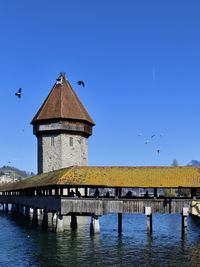 View of bridge over water against clear blue sky