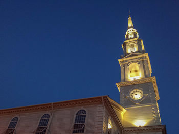 Low angle view of clock tower against clear blue sky