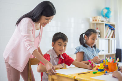 Teacher helping student in classroom