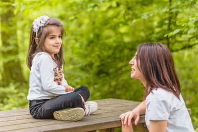 Mother and daughter sitting outdoors