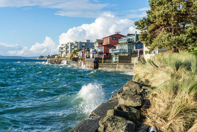 Waves on a windy day hit the shoreline near waterfront homes in west seattle, washington.