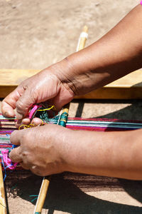 Cropped image of woman making craft on field