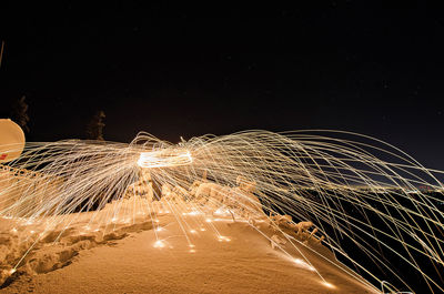 Wire wool on cliff against sky at night