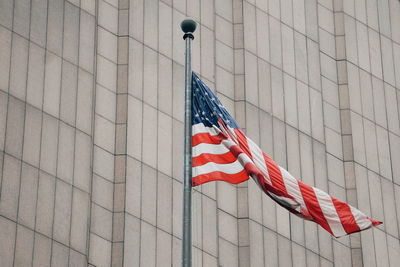 Low angle view of american flag against building in city