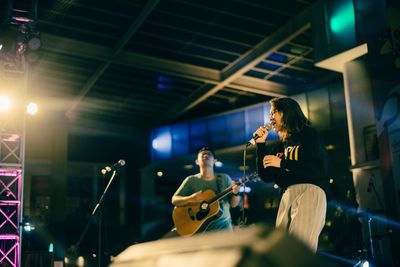 People playing guitar at music concert