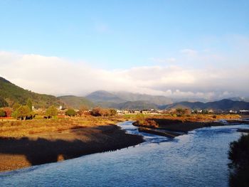 Scenic view of river and mountains against sky