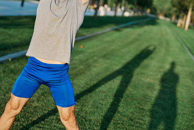 Low section of man standing on grass