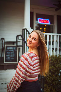 Portrait of young woman standing in city