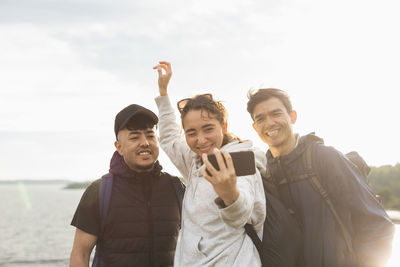 Smiling friends taking selfie