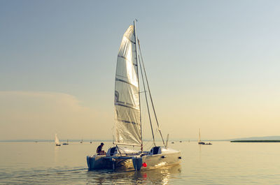 Sailboat on sea against sky during sunset