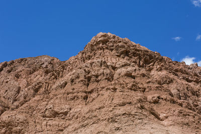 Low angle view of rock formations against clear blue sky